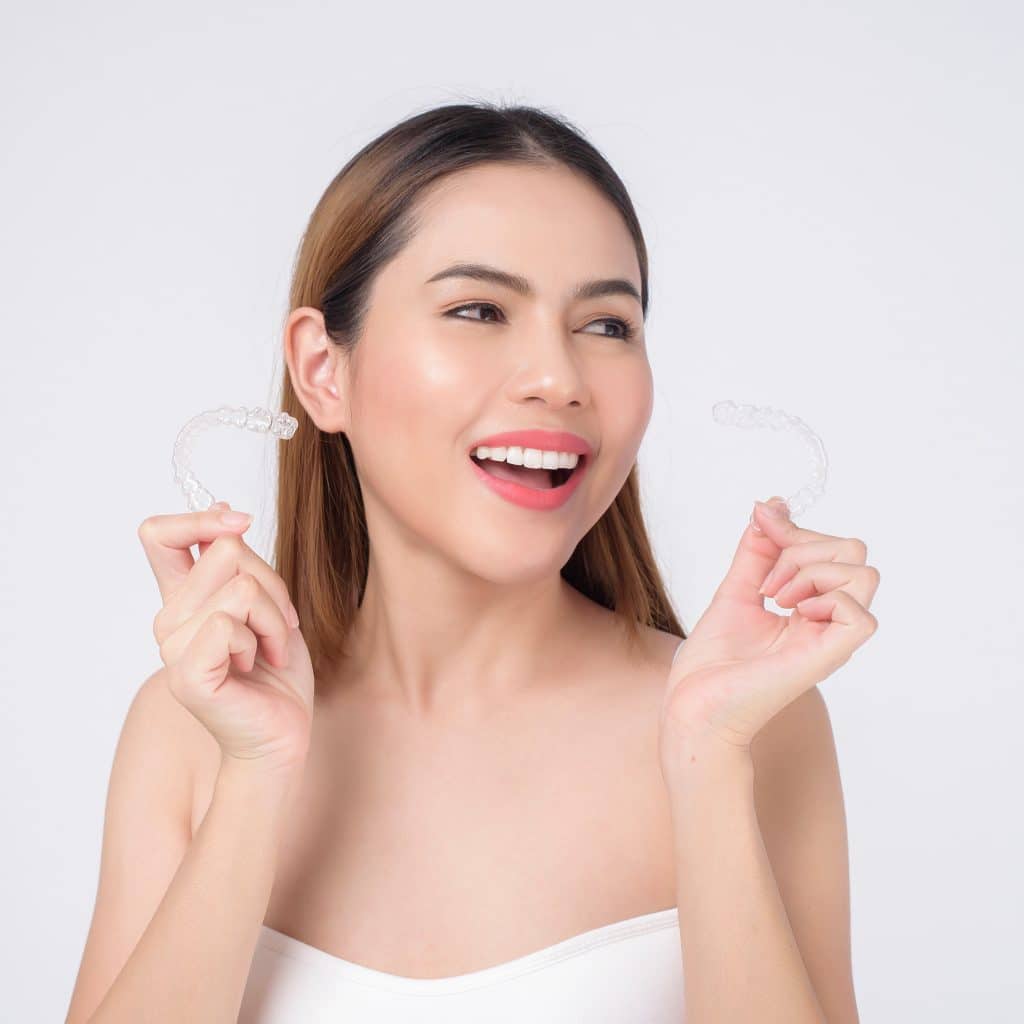Frau nutzt Invisalign für schönere Zähne